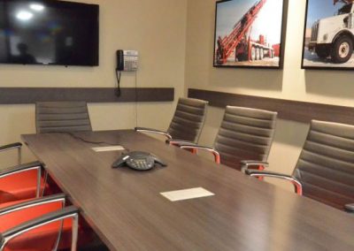 Meeting space with board room table and custom red leather chairs