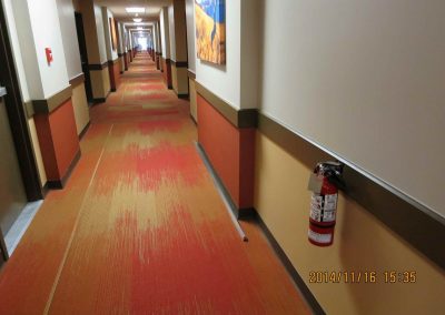 Commercial office hallway with geometric yellow and red carpet