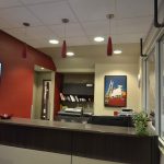 Commercial reception desk with red feature wall and red lighting