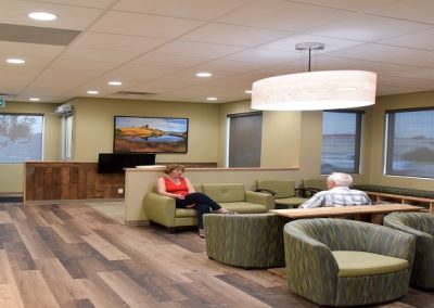 Large waiting room with wooden floors and large stone feature wall
