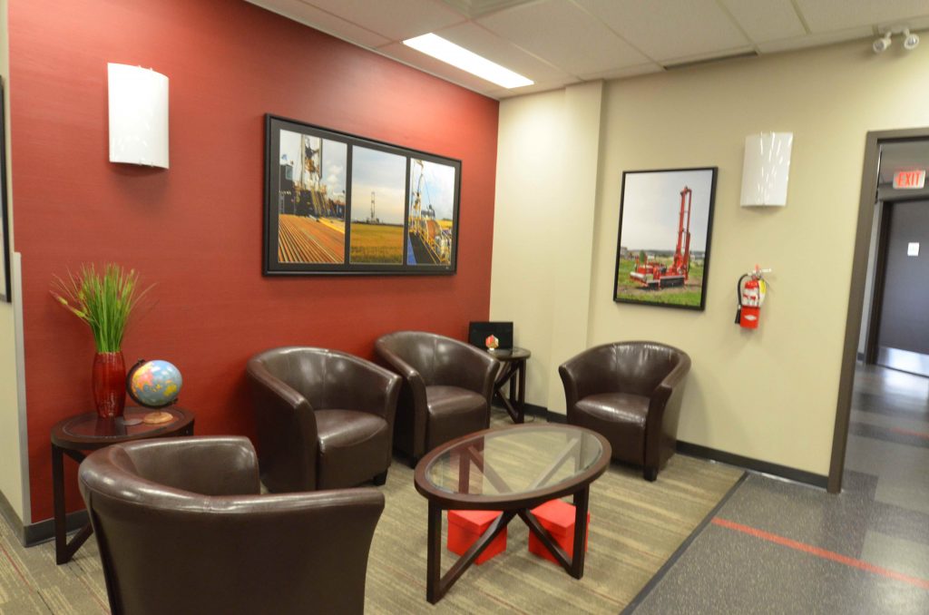 Commercial office waiting room with red feature wall and leather couches