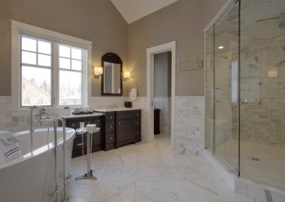 Large white themed master bathroom with window letting in light through window