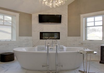 Large open concept master bathroom with white soaker tub and dark wooden vanities