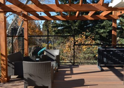 Wooden pergola above patio with glass railings