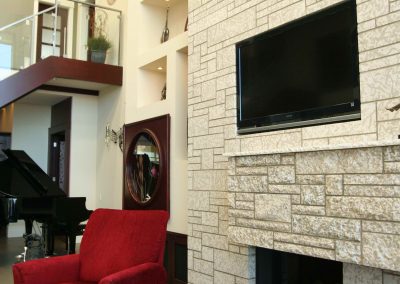 Stone wall with built in fireplace and tv above fireplace