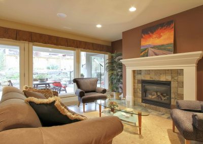Family room seating area with furniture facing stone fireplace