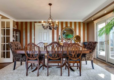 Dining room with large dining room table and a striped feature wall paper wall