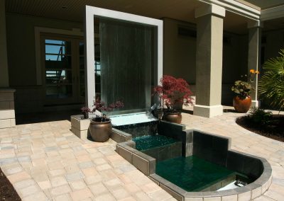 Custom outdoor water feature flowing into pond