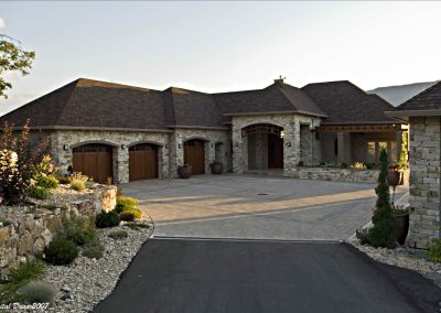 Residential exterior of custom home design with large driveway leading up to house
