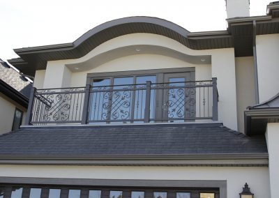Arched roof above master bedroom balcony with black railings