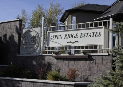 Aspen Ridge Estates sign on community fence surrounded grey bricks