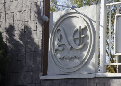 Close up of Aspen Ridge Estates logo on white cement fence