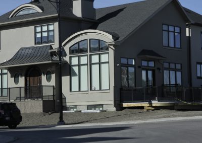 New custom home with large arching windows and black trim