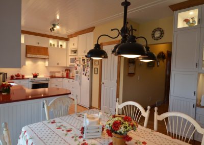 Country style kitchen with white ceilings and red accents on counters