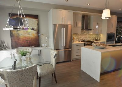 White modern kitchen renovation with glass table, white features and a long white island
