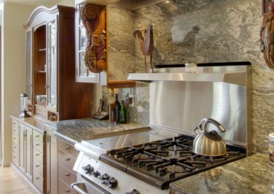 Granite backsplash surrounding stainless steel oven top