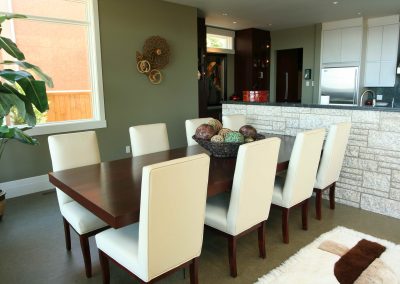 Wooden dining room table and white upholstered dining room chairs