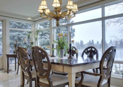 Eleganat styled dining room table surrounded by floor to ceiling windows