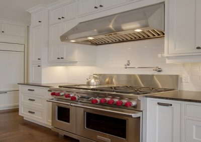Wolf oven surrounded by custom white kitchen cabinets