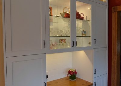 Built in kitchen desk surrounded by custom white kitchen cabinets
