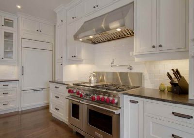 Residential kitchen renovation with white backsplash and matching white custom cabinets