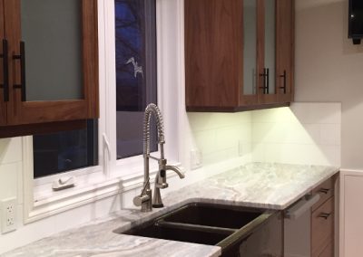 modern kitchen with dark brown cabinets and a deep black granite kitchen sink