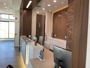 Modern front desk with silver accents and tiered lighting